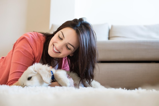 子犬と一緒に床に横たわっている女性