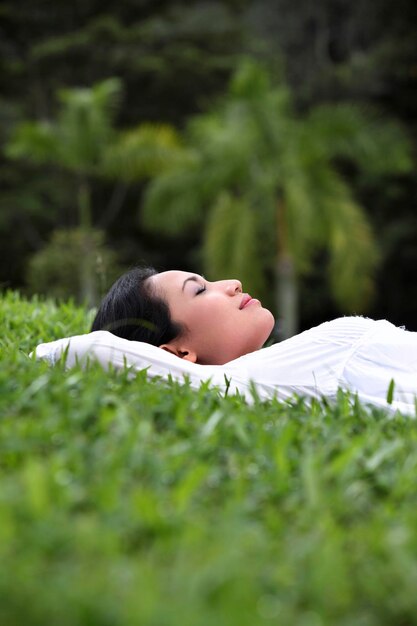 Photo woman lying on grassy field at park