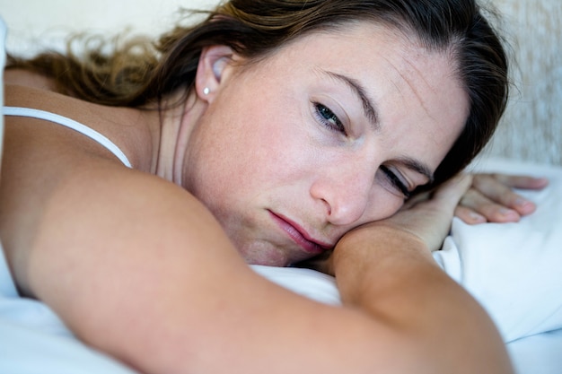 woman lying in her bed looking tired