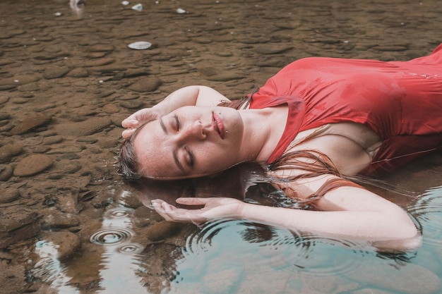 Foto donna sdraiata nel lago nella foresta
