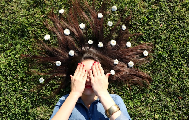 사진 머리카락 에 꽃 이 있는 눈 을  ⁇ 고 잔디 에 누워 있는 여자