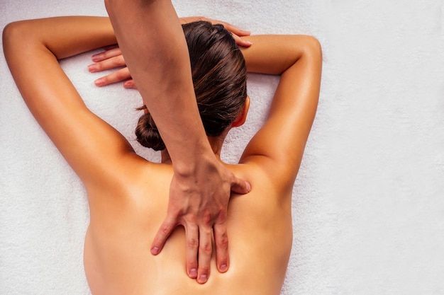 Photo woman lying on the table and getting ayurvedic massage with organic oil or honeyed in dark room.massagist making yoga massage .