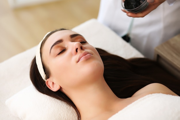 woman lying on the table wrapped in a towel in the spa.