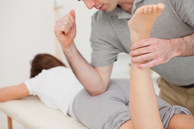 woman lying while being massaged by her doctor