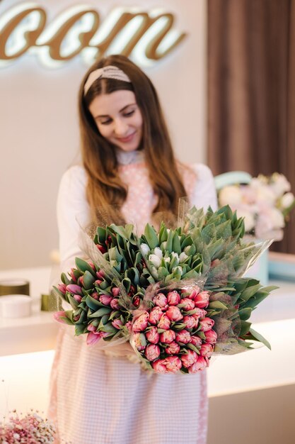 女性は春の花束を作る女性の花屋は春の花の花束を保持する美しい花の構成