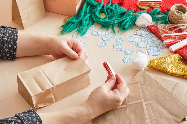 a woman makes an advent calendar with her own hands, the process of creating a calendar with numbers