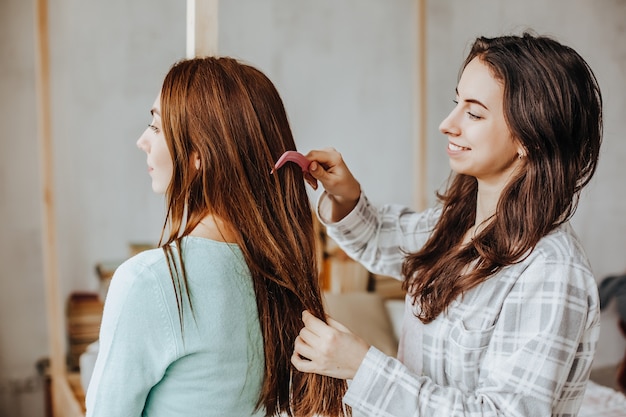 Photo woman makes a braid to her friend