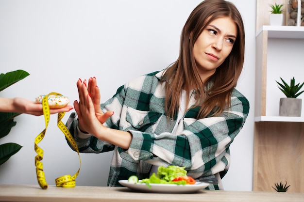 Woman makes a choice between healthy and harmful food.