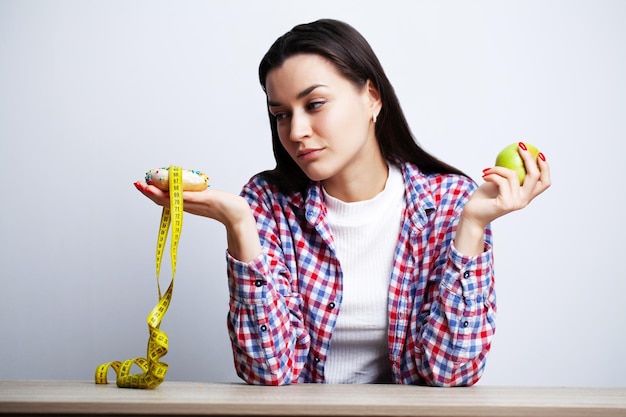 Woman makes a choice between healthy and harmful food