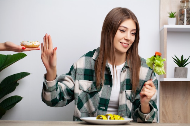 Woman makes a choice between healthy and harmful food