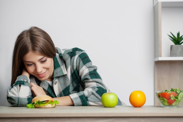 Woman makes a choice between healthy and harmful food