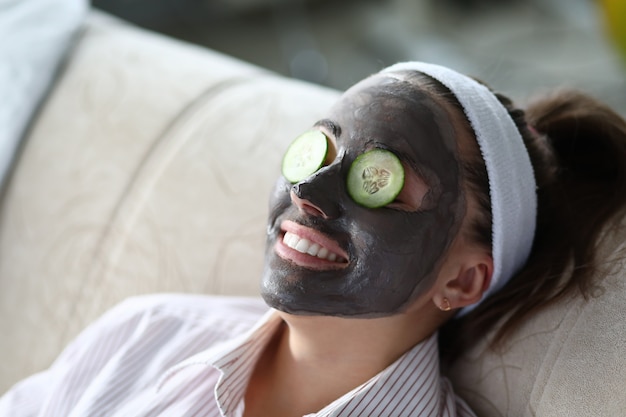 Woman makes gray clay facial mask at home