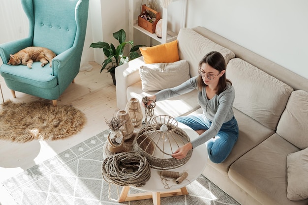 Foto la donna realizza a casa una lampada fai-da-te fatta a mano con una corda di iuta