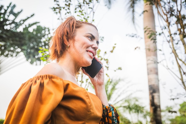 A woman makes a phone call while in a botanical garden