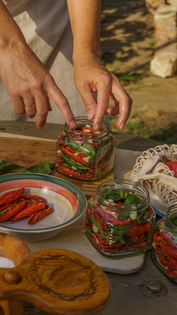 woman makes preparations for winter: dried tomatoes, chopped garlic and fresh basil