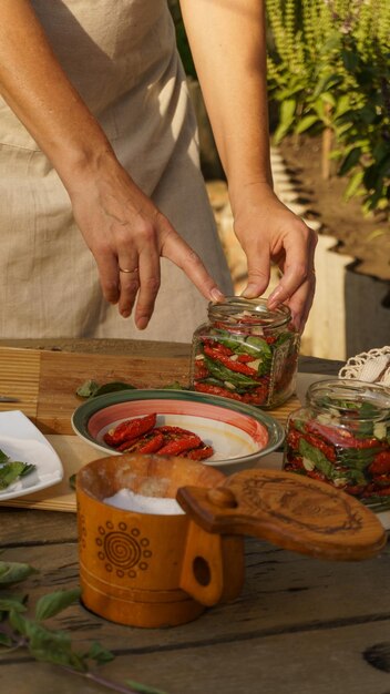 woman makes preparations for winter - dried tomatoes, chopped garlic and fresh basil