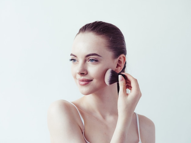 Woman makeup powder applying skin face  beautiful female natural portrait.