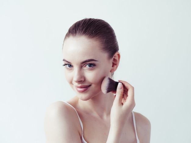 Woman makeup powder applying skin face  beautiful female natural portrait.