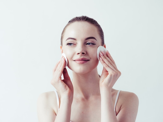 Polvere di trucco della donna che applica il bello ritratto naturale femminile del fronte della pelle.