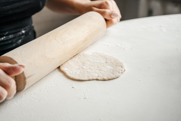 woman making bread pastry knead the dough kneading on the kitchen table at home