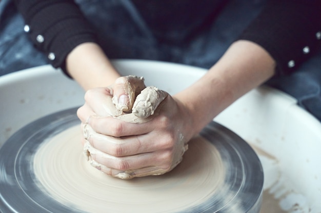 Woman making ceramic pottery on wheel