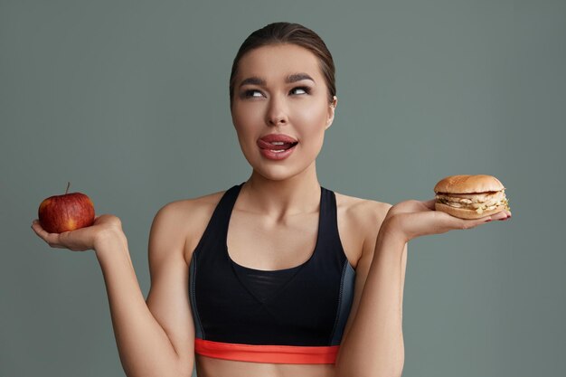 Photo woman making choice between apple and hamburger dieting concept healthy eating