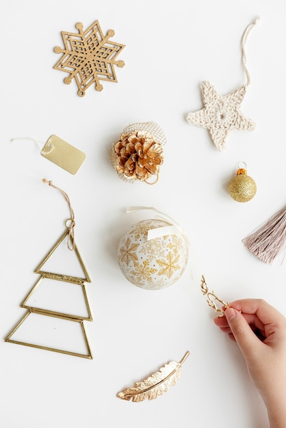 Woman making a Christmas tree with gold ornaments aerial view