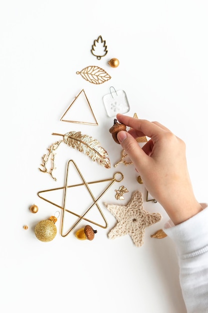 Woman making a Christmas tree with gold ornaments aerial view