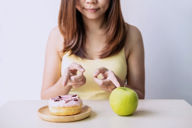 Donna che prende una decisione tra cibo sano e cibo malsano, concetto di stile di vita sano e dieta