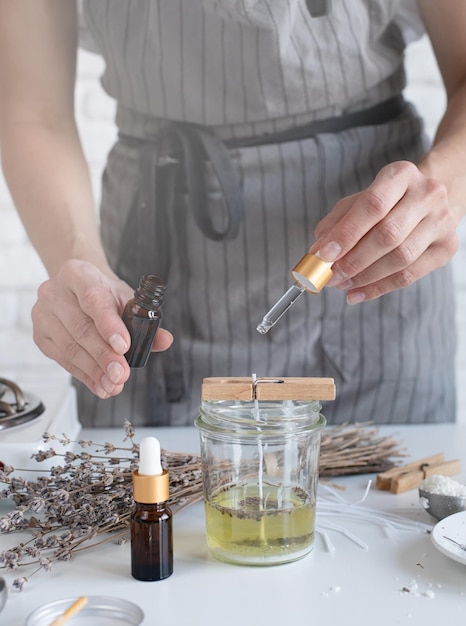 Woman making decorative aroma candle at table closeup