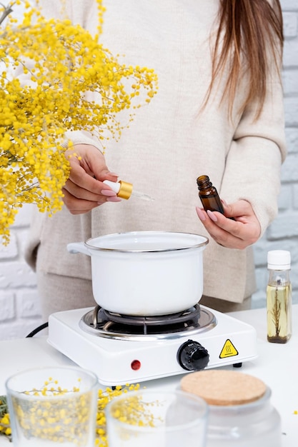 Woman making decorative aroma candle at table closeup