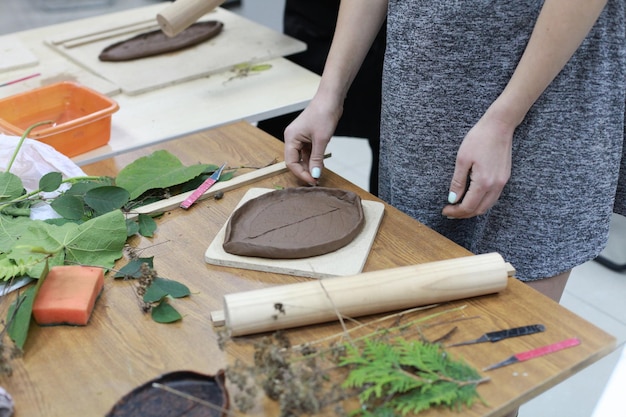 Photo woman making design in clay at workshop