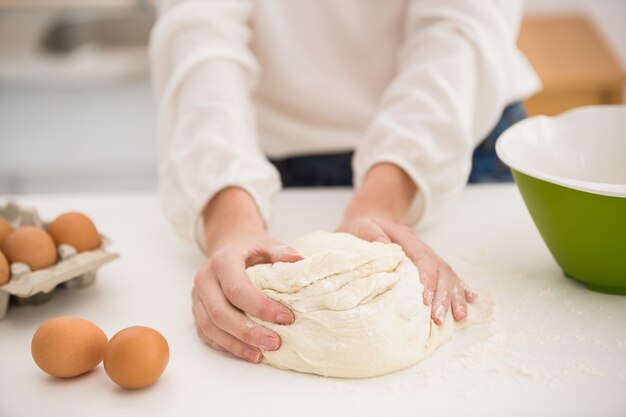 Woman making dough on counter