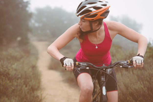 산악 자전거와 함께 내리막을 만드는 여자. 사람과 스포츠에 대한 개념
