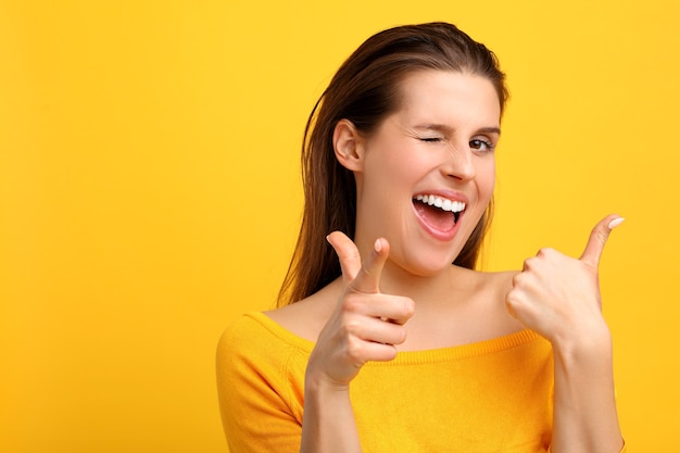 woman making faces against yellow