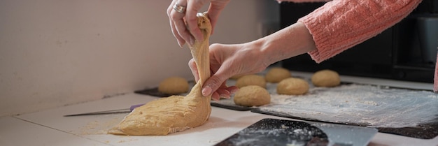 Donna che fa i panini di pane fatti in casa freschi