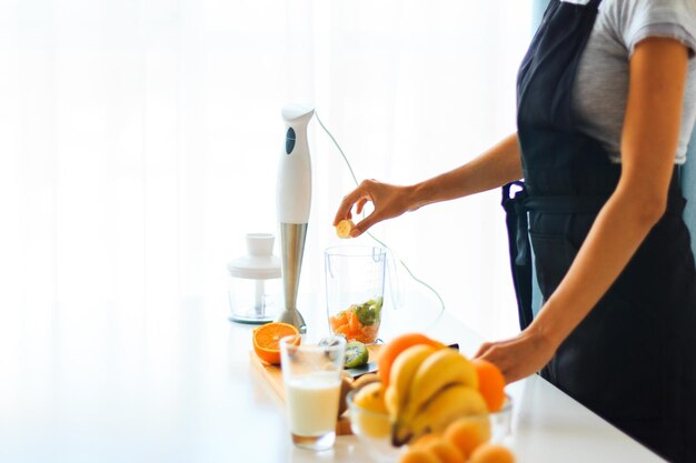 Woman making fruit smoothie. Detox day