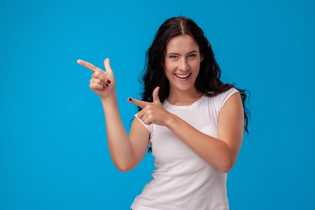 Woman making gun gesture on blue background