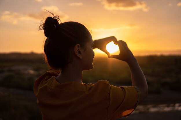 Foto donna che fa il segno della mano del cuore