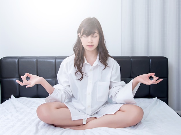 woman making meditation on bed