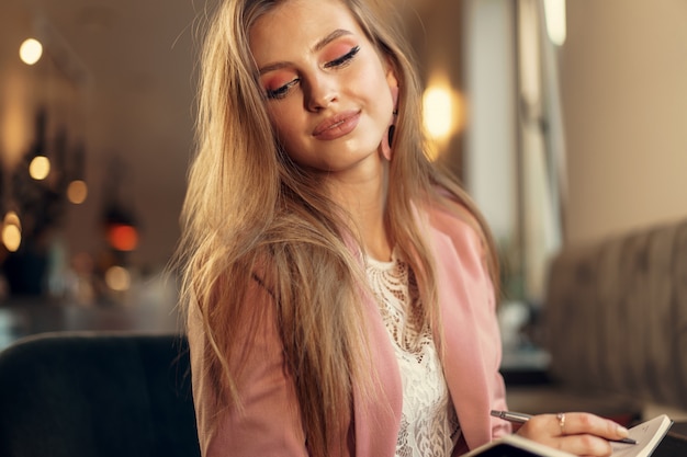 Woman making notes while sitting in a coffee shop