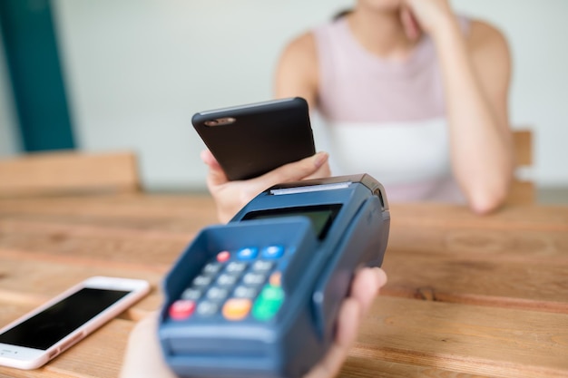 Женщина совершает платеж с использованием технологии NFC