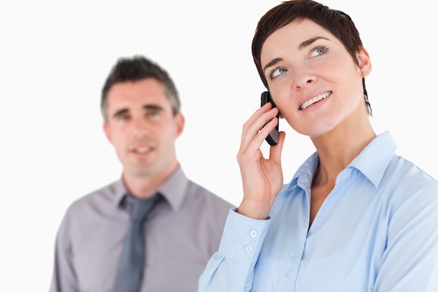 Woman making a phone call while her colleague is posing