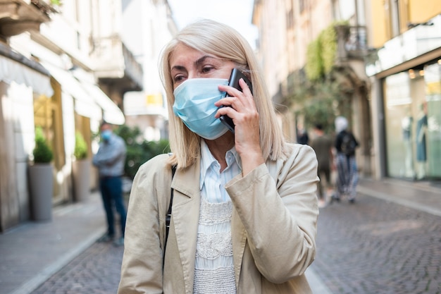 Woman making a phone call while wearing a mask