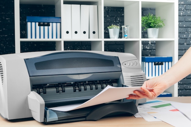 Woman making photocopy using copier in office