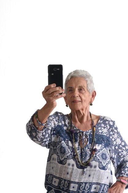 Женщина делает портрет с телефоном на белом