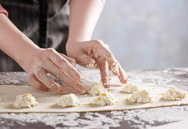 Woman making ravioli on table