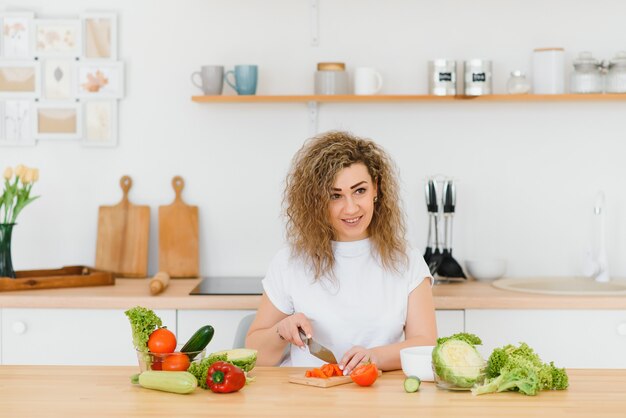 Woman making salad in kitchen. 