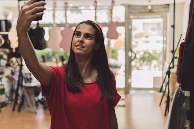 Woman making a selfie with the mobile in a instruments store