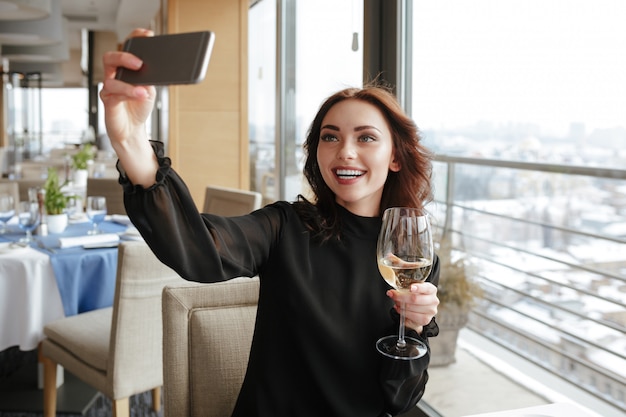 Donna che fa selfie con bicchiere di vino